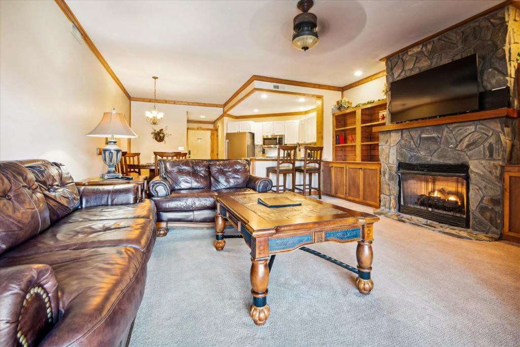 Una sala de estar con muebles de cuero y chimenea. en Smoky Haven, en Pittman Center