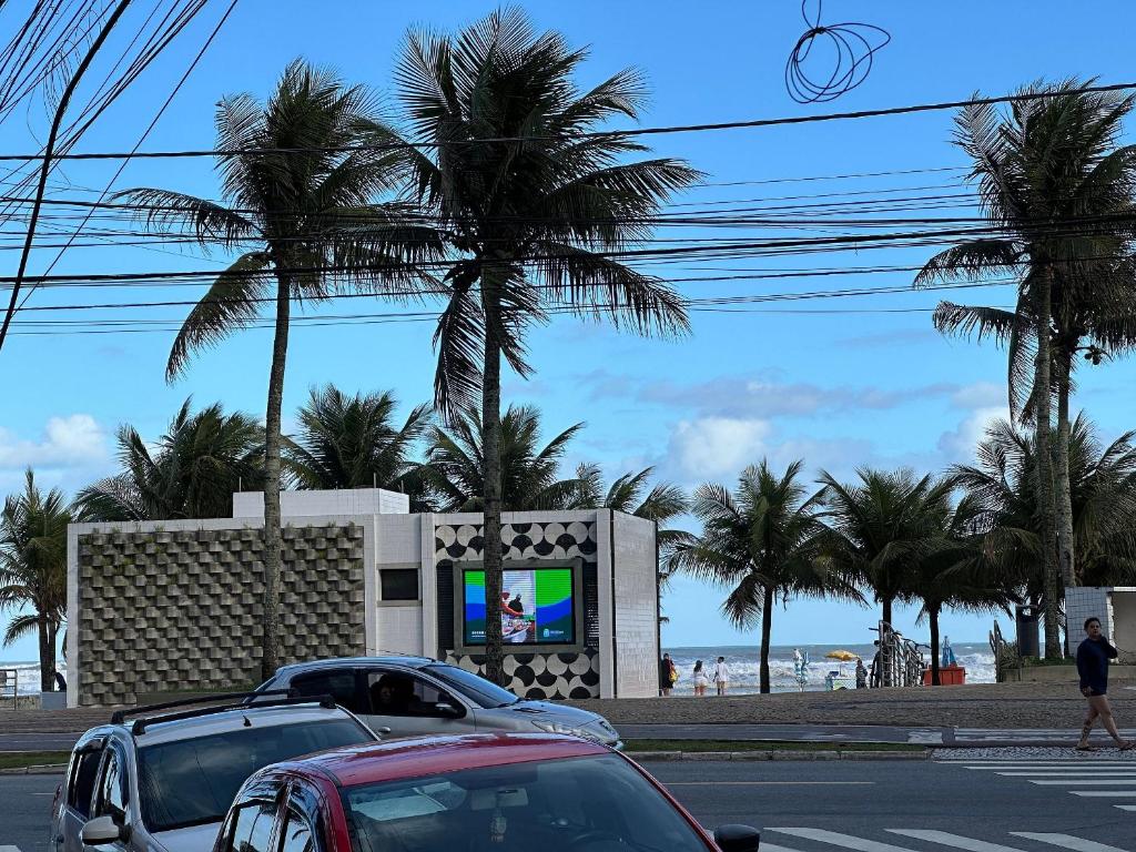a parking lot with cars parked in front of the beach at Pé na areia em Nova Mirim com Wi-Fi e conforto! in Samaritá