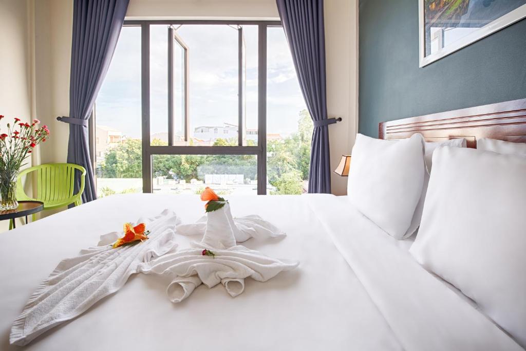 Postel nebo postele na pokoji v ubytování Hoi An Green Apple Hotel