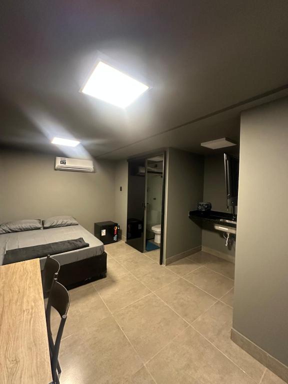 ein Schlafzimmer mit einem Bett und einem Fernseher darin in der Unterkunft Kit Aconchegante na Asa Norte - Centro in Brasilia