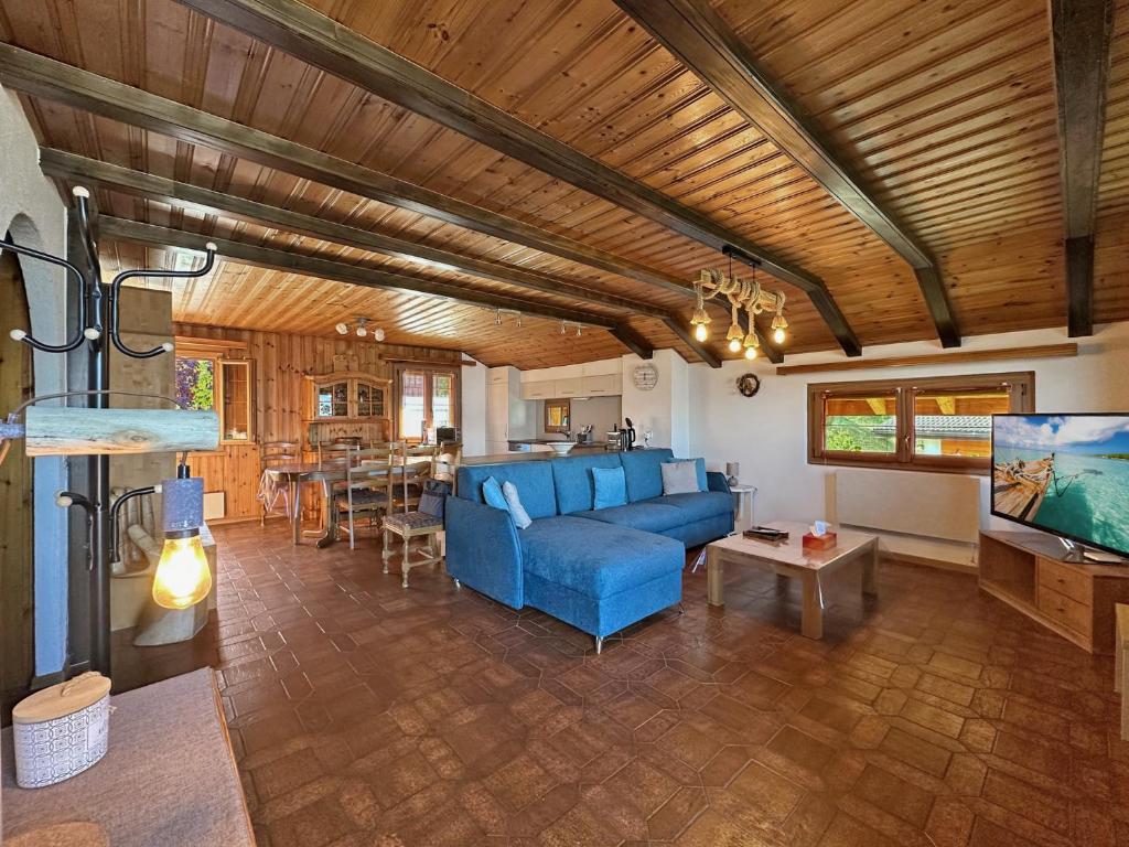 a living room with a blue couch and a table at Bear Ridge Retreat - 8mns to slopes - Swiss Alps in Agettes