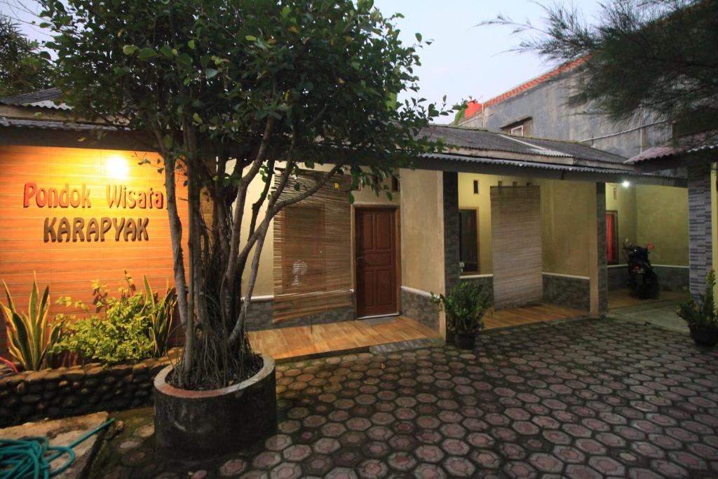 a building with a tree in front of it at Pondok Wisata Karapyak Jajapin in Nusa Were