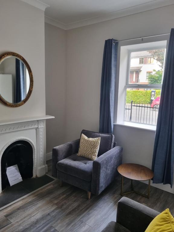 a living room with a couch and a chair and a mirror at Adare House Newbridge in Newbridge