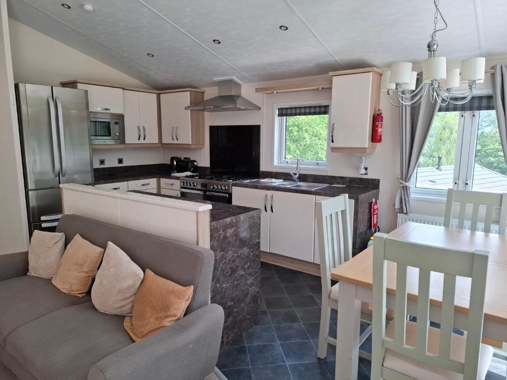 a kitchen and living room with a couch and a table at Woodland Lodge - 2 Bedroom Spacious Lodge Sleeps 4 in Hastings