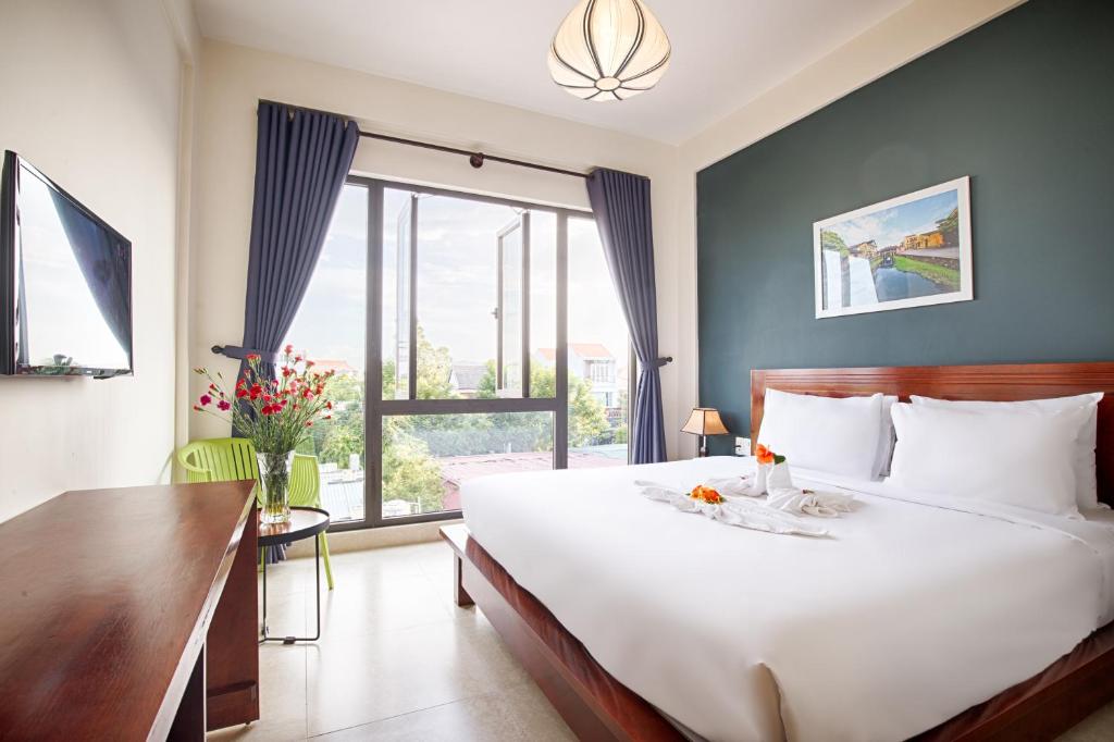 Postel nebo postele na pokoji v ubytování Hoi An Green Apple Hotel