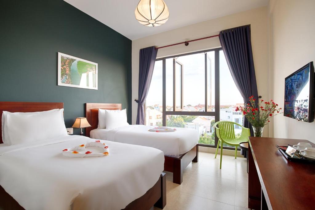 Postel nebo postele na pokoji v ubytování Hoi An Green Apple Hotel