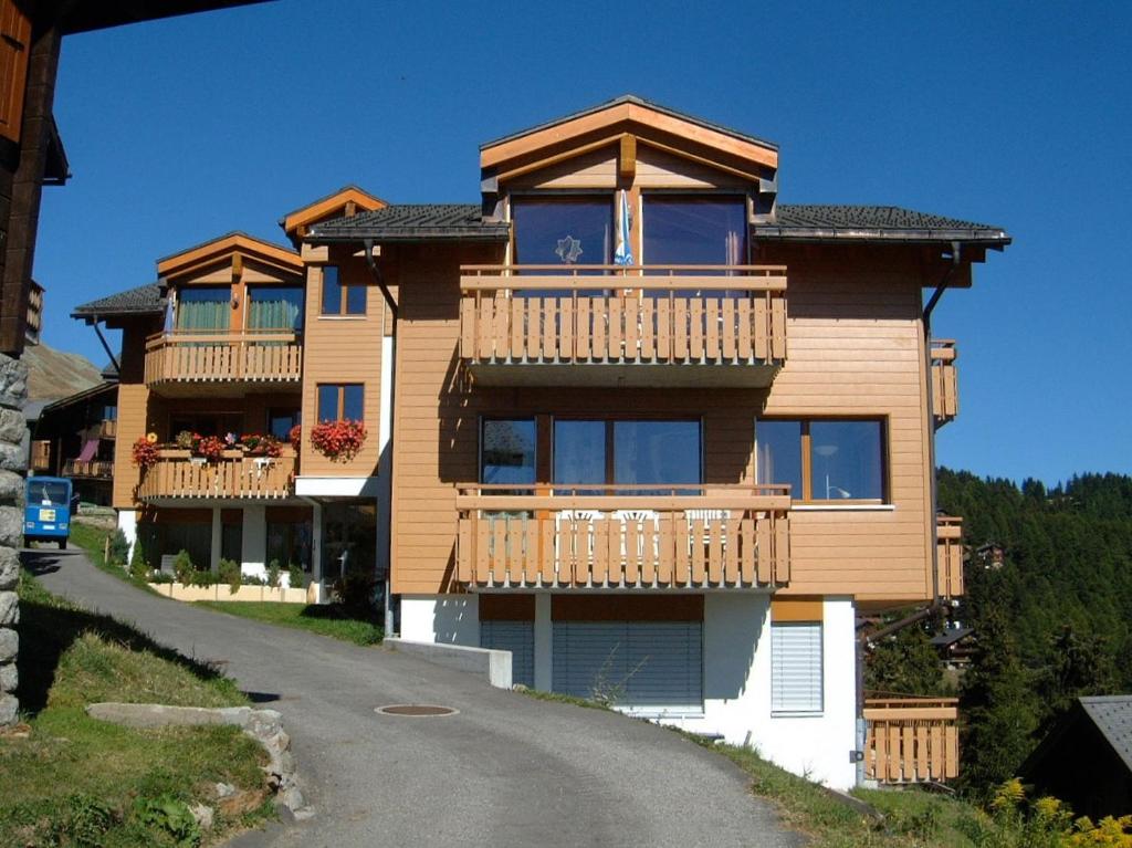 ein großes Haus mit Balkon auf einer Straße in der Unterkunft Haus Alpsägu, Bettmeralp in Bettmeralp