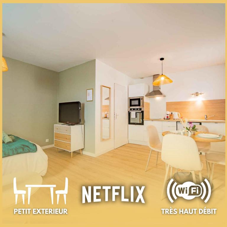 a bedroom with a bed and a table and a kitchen at Le Nid Tourangeau - Calme - Wifi - Parking in Monnaie