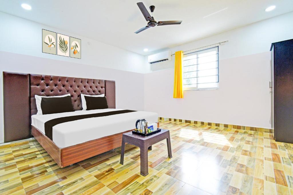 a bedroom with a bed and a ceiling fan at Hotel O Stayo Inn in Hyderabad