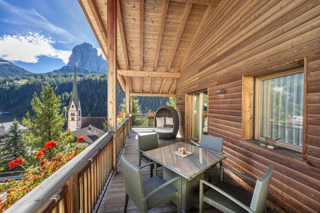 terraza con mesa y sillas en el balcón en Mayr Natur Apartments, en Santa Cristina Valgardena