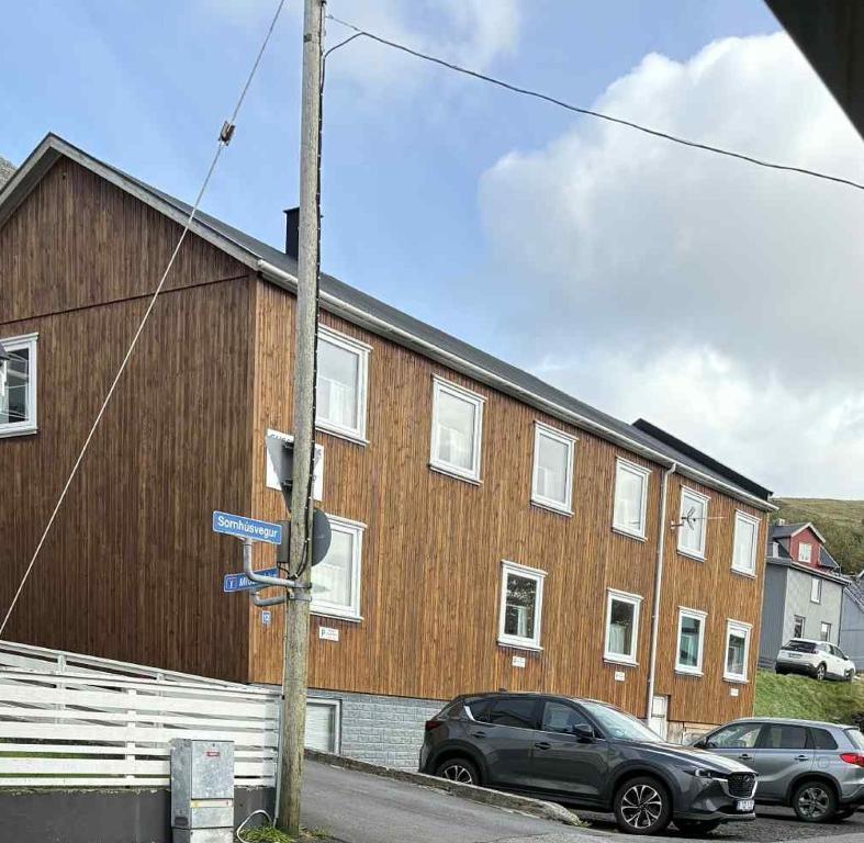 a pole with a street sign in front of a building at Midbrekkan apartment in Tvøroyri