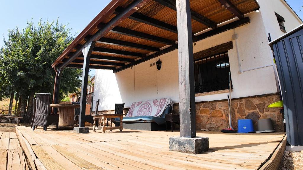 a covered patio with a bench and a table at Ruralux Orcera Linarejos I in Orcera