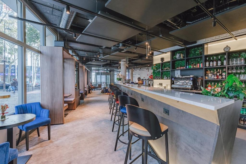un bar dans un restaurant avec des chaises et des tables dans l'établissement Appart'City Collection Paris Gare de Lyon, à Paris
