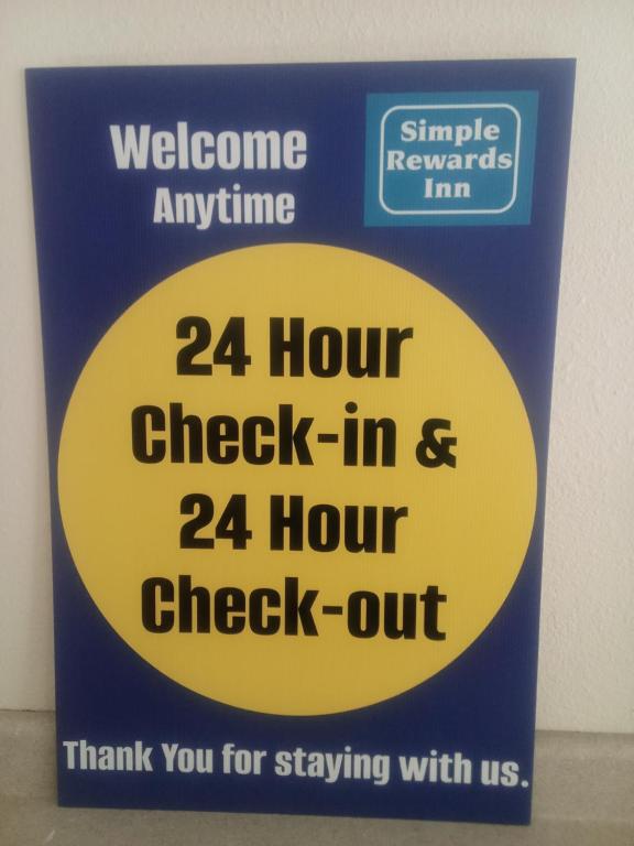 a sign for a hour check in and hour check out at Simple Rewards Inn in Hilton Head Island