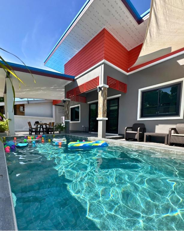 a swimming pool in front of a house at PoolvillaLana 3 rooms in Bang Sare