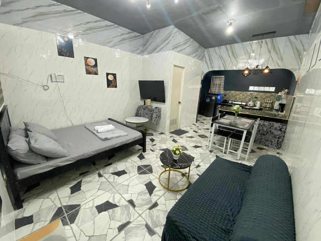 a room with a bed and a kitchen in a tent at CASA Sapphira Transient House in Santo Tomas