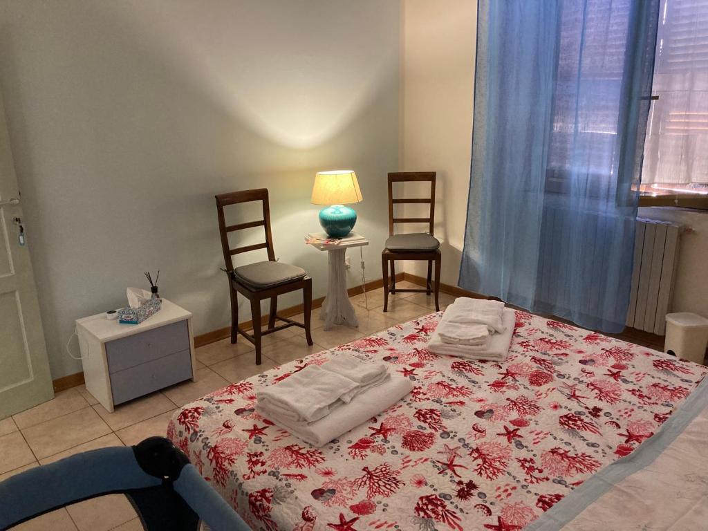 a bedroom with a bed with two chairs and a lamp at Angolo Di Michele e Sergio in Foligno
