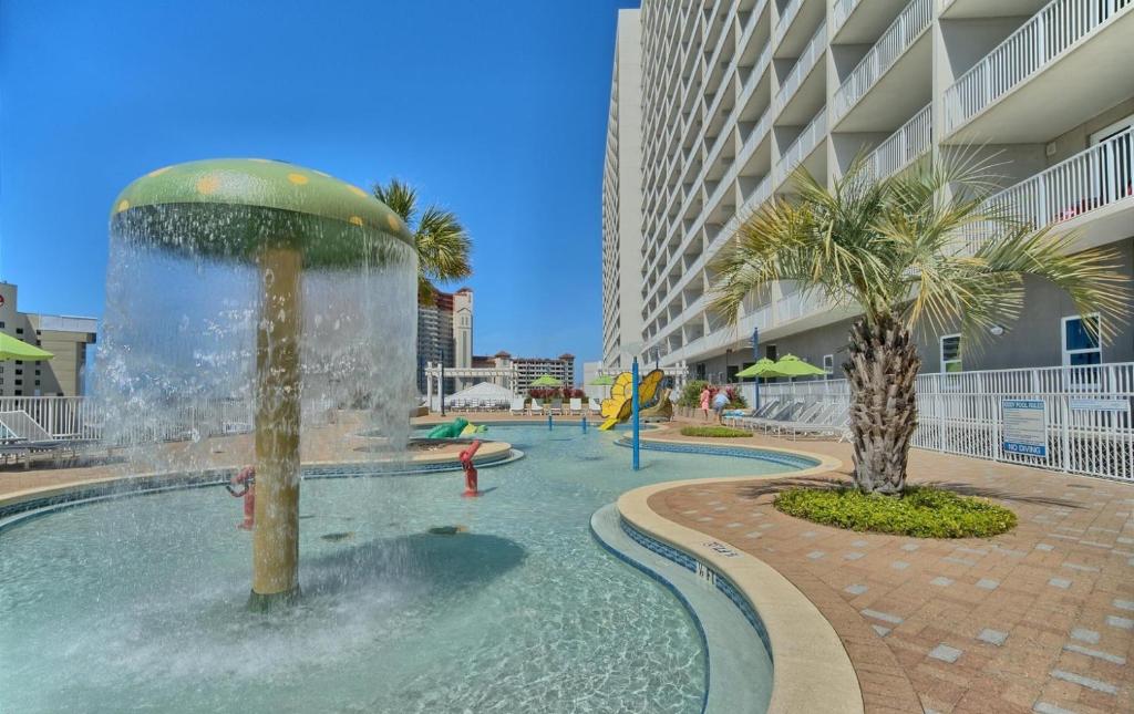 a swimming pool with a fountain in the middle of a building at Laketown Wharf 933 in Panama City Beach