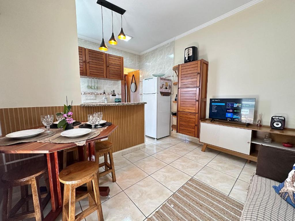 a kitchen with a table and chairs and a refrigerator at Apto no Boqueirão, 5 min da praia + Wi-Fi! in Praia Grande