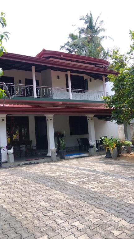 a white building with a balcony and a patio at Casa del Mar in Ahungalla