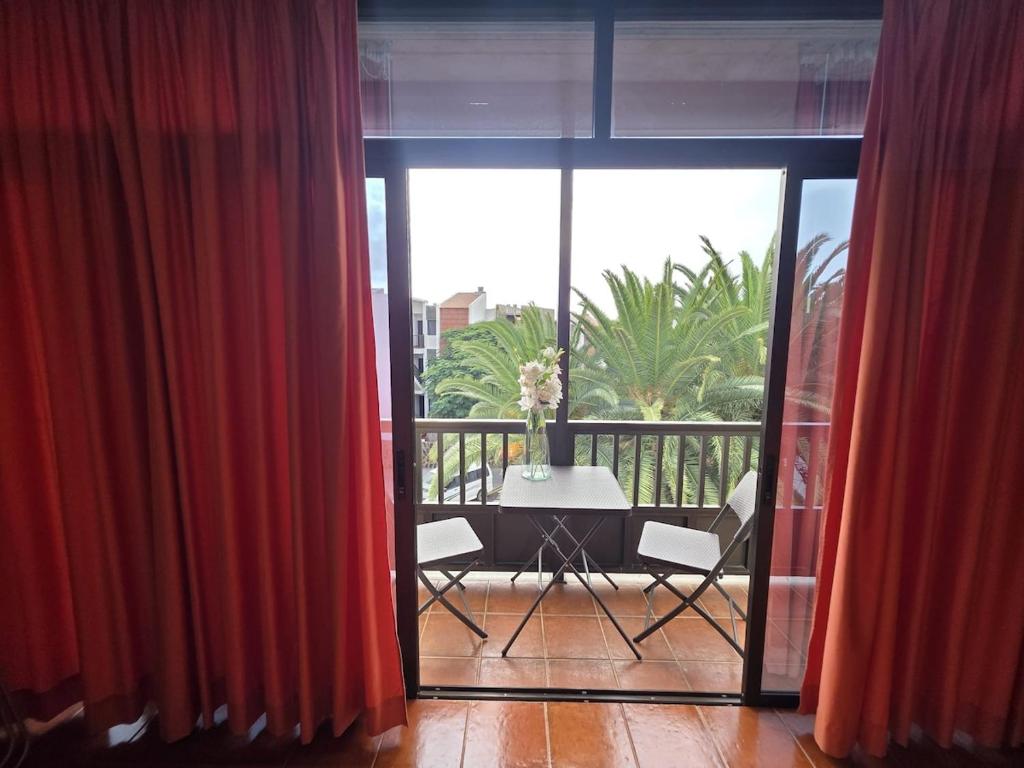 a balcony with red curtains and a table and chairs at Miel de Guarapo Apartment 