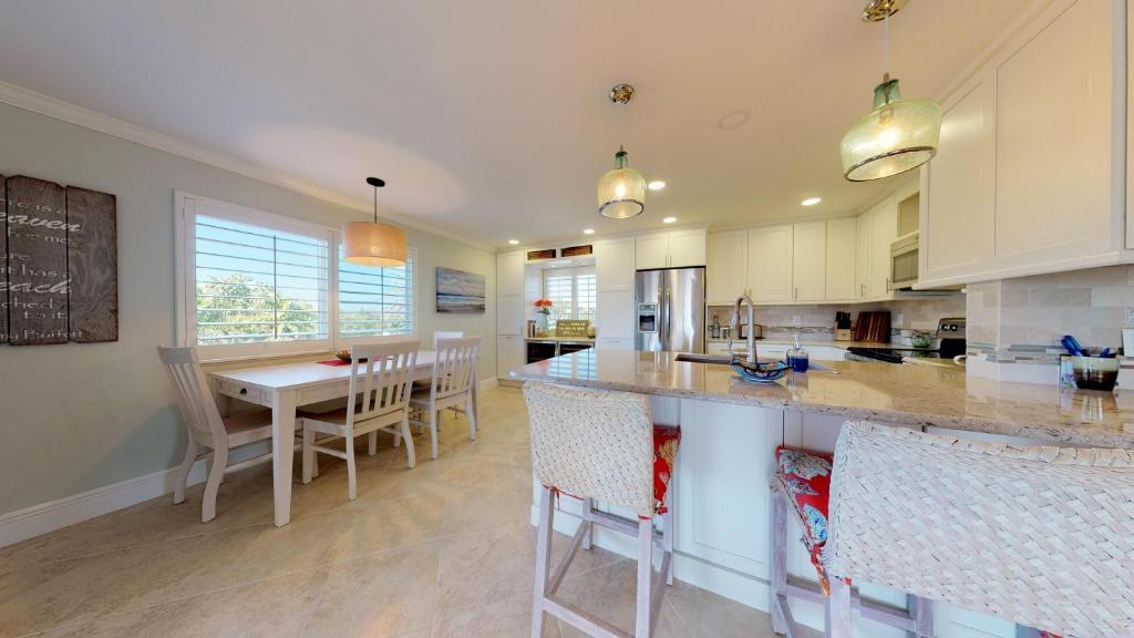 cocina con isla y mesa con sillas en Sanibel Surfside 226, en James Cipriani Heliport