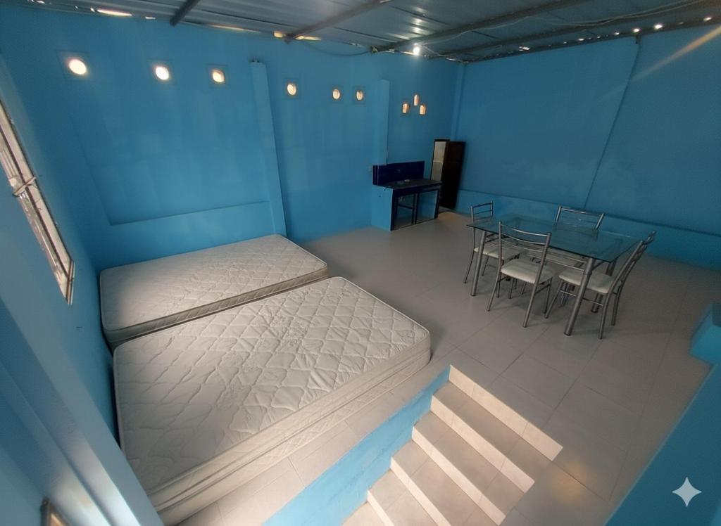 a blue room with a bed and a table and chairs at Apartamento 4 personas solo para dormir en Manta in Manta