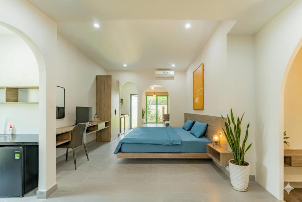 a bedroom with a blue bed and a desk at Na Garden Homestay in Hue