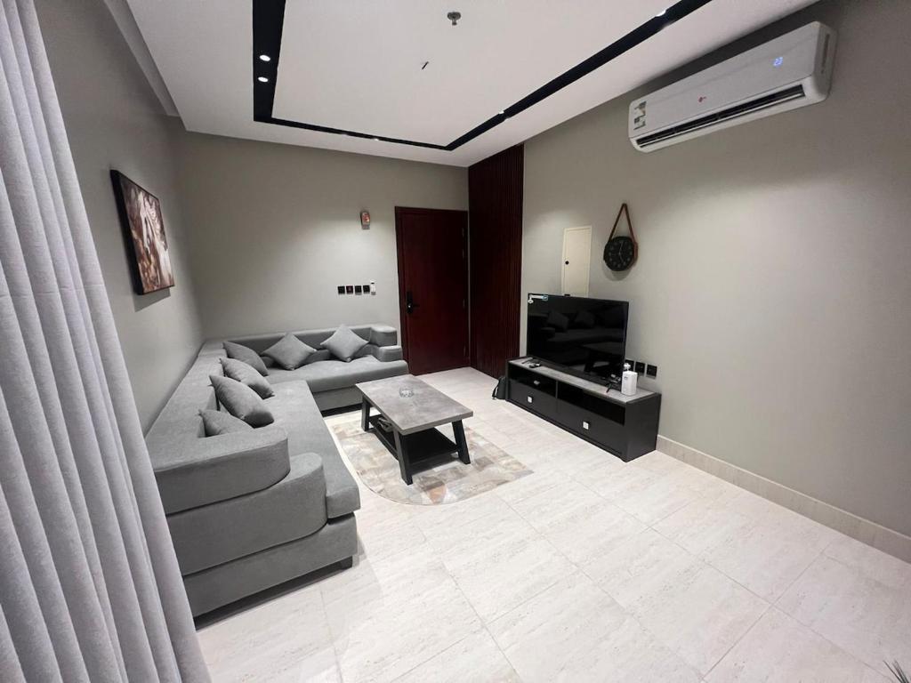 a living room with a couch and a television at Quiet and comfortable apartment near Rakka Sea in Dammam
