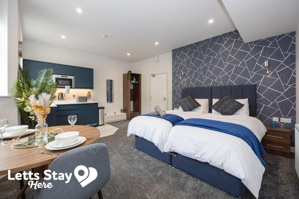 ein Schlafzimmer mit großem Bett und ein Esszimmer in der Unterkunft Eden Bay Serviced Apartments - Eden in Morecambe