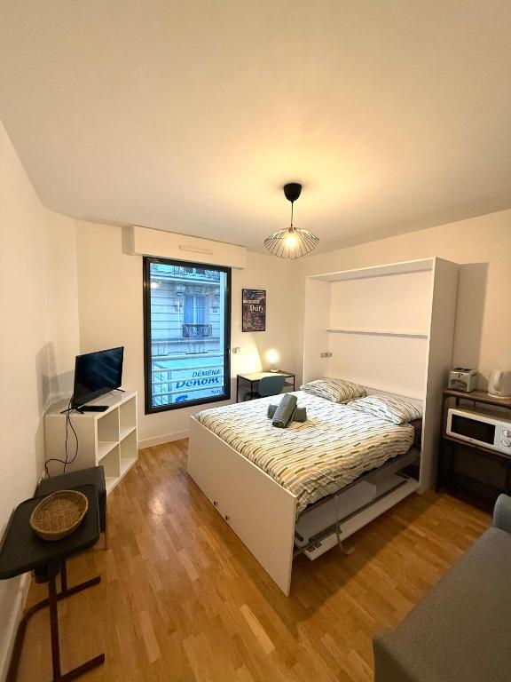Un dormitorio con una cama y un escritorio y una ventana. en Studio Boileau Tour Eiffel, en París