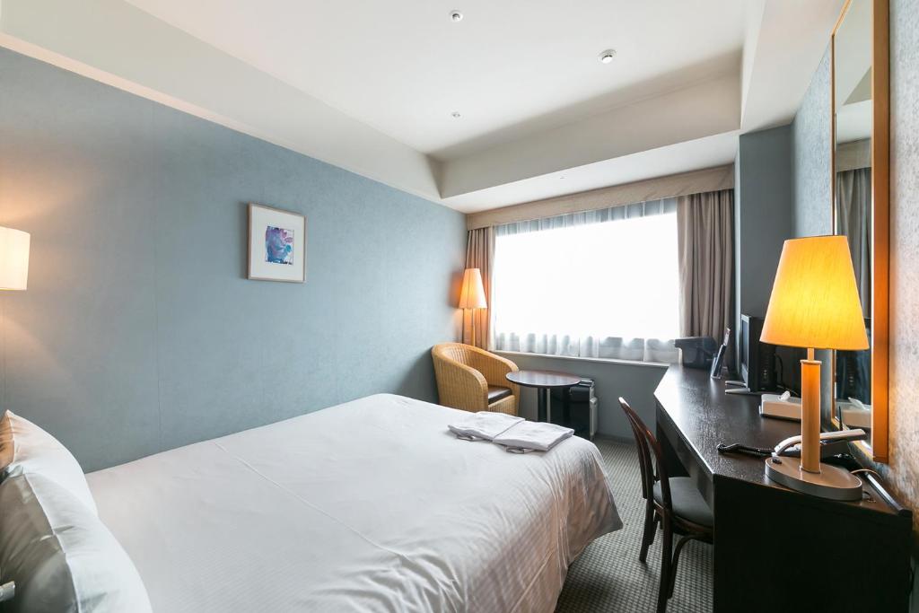 Postel nebo postele na pokoji v ubytování Yokohama Techno Tower Hotel