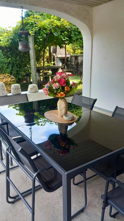 a glass table with a hat and flowers on it at Casa Camelia in Intragna
