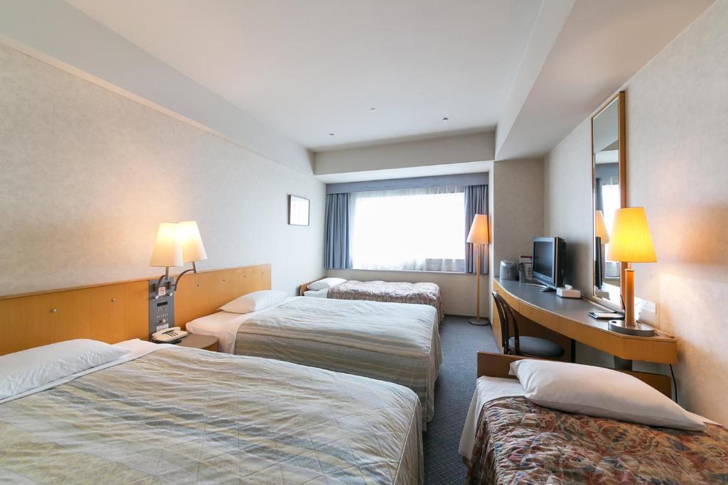 Postel nebo postele na pokoji v ubytování Yokohama Techno Tower Hotel