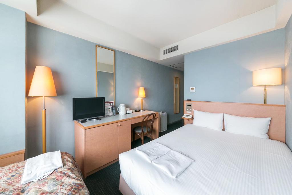 Postel nebo postele na pokoji v ubytování Yokohama Techno Tower Hotel