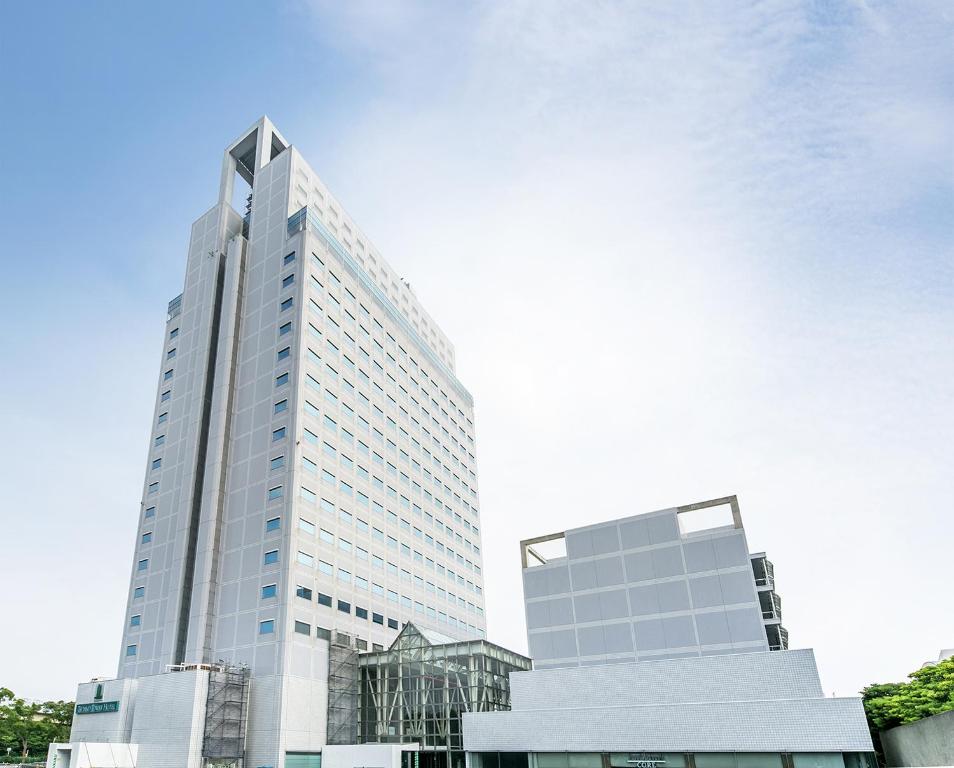 Un alto edificio bianco con un cielo di Yokohama Techno Tower Hotel a Yokohama