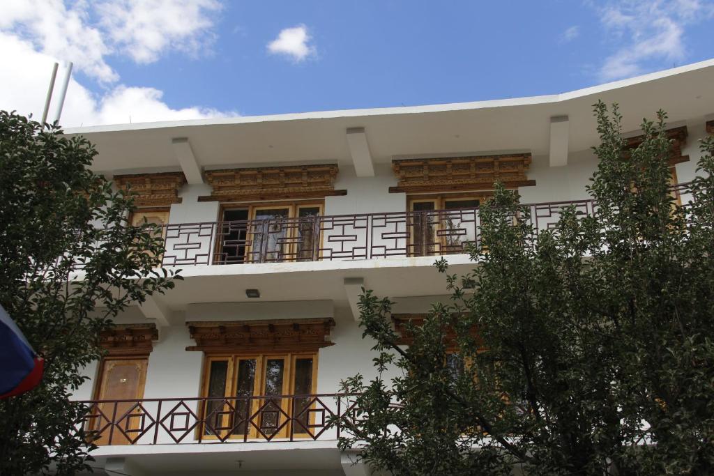 a building with a balcony on the side of it at Mentokling Guest House and Garden Restaurant in Leh