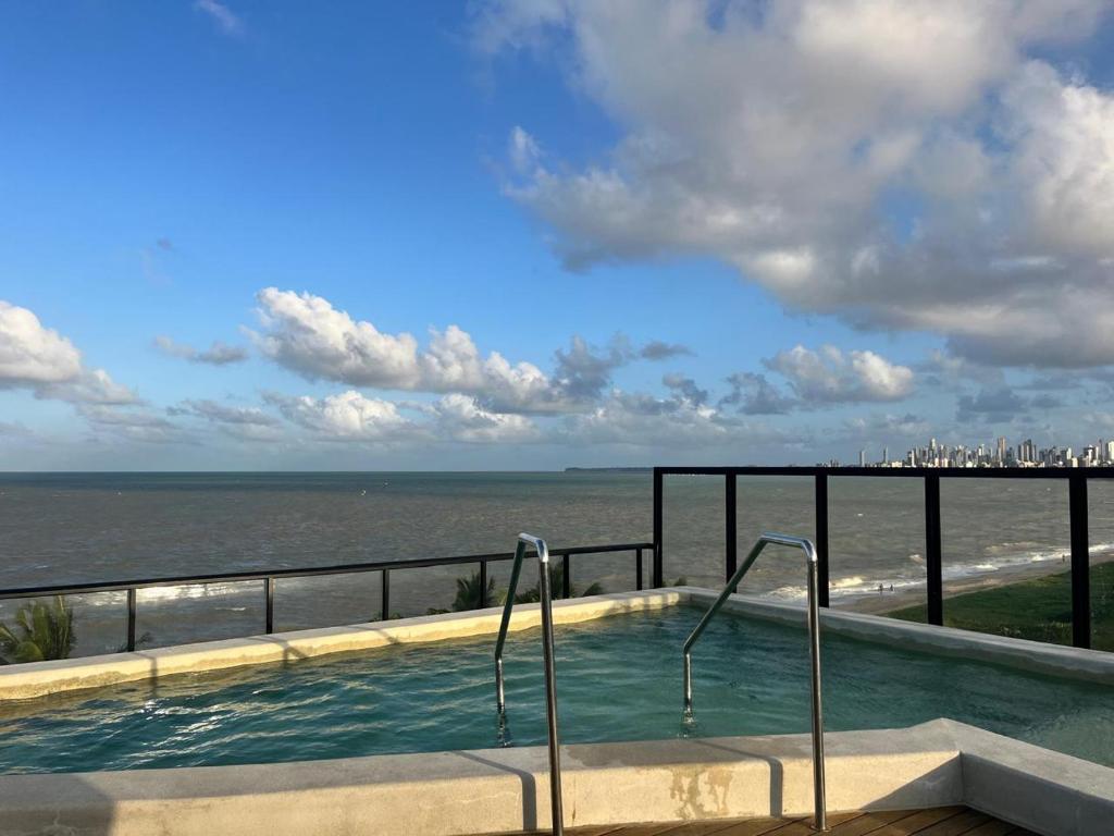 a swimming pool with a view of the ocean at Luxuoso Flat pé na areia no Restinga in João Pessoa