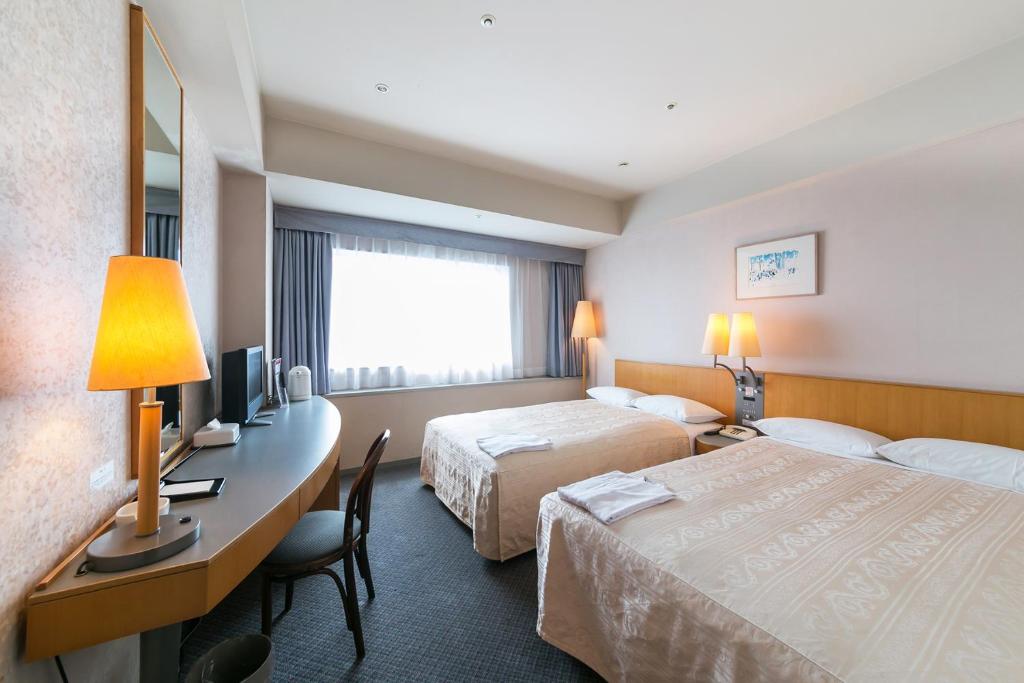 Postel nebo postele na pokoji v ubytování Yokohama Techno Tower Hotel