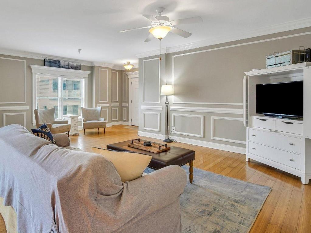 a living room with a couch and a flat screen tv at Silver Seas 103 in Tybee Island
