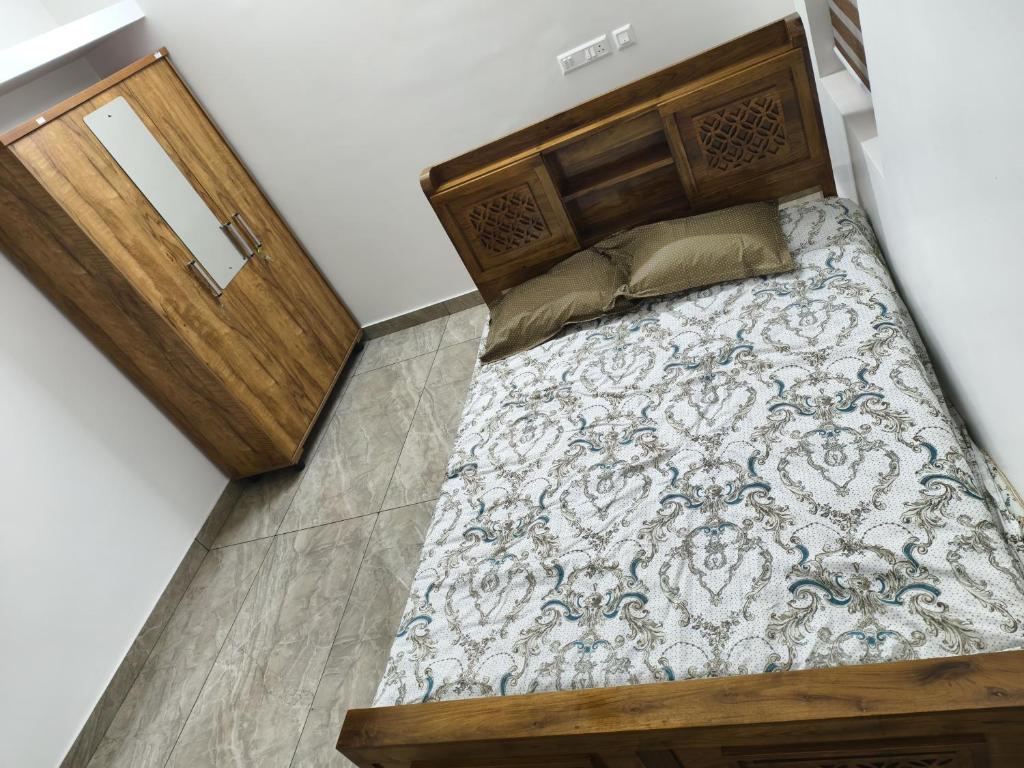 a bedroom with a large bed with a wooden headboard at White Shadow in Varkala