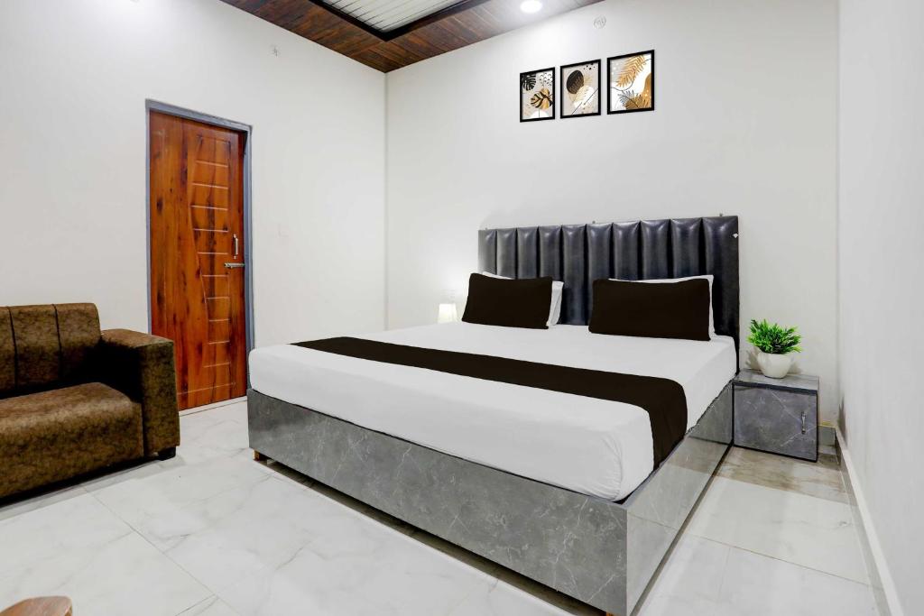 a bedroom with a large bed and a chair at Hotel O Aparna and Marriage Lawn in Balrāmpur