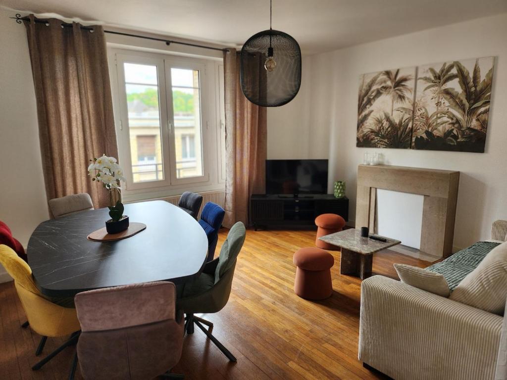 a living room with a table and a couch at T3 Le logis de Martin - city center - near Ducale Place with parking space in Charleville-Mézières