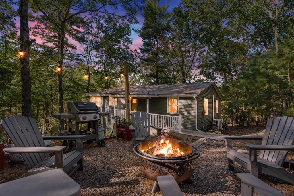 a grill and chairs in front of a cabin at Family Cabin w Fireplace Fire Pit Grill Trail Access in Baxter