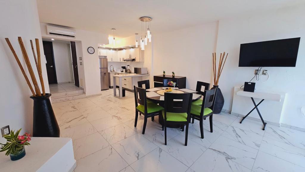 a living room with a table and chairs and a kitchen at departamento frete al mar in Manzanillo