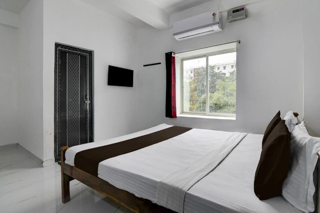 a bedroom with a large bed with a window at Hotel O Shree Guest House in Khandagiri