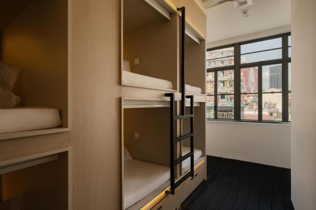 a room with bunk beds and a window at BEAT 1932 Hostel at Chinatown in Singapore
