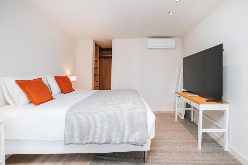 a bedroom with a white bed and a desk at Apartment Oro in Braga