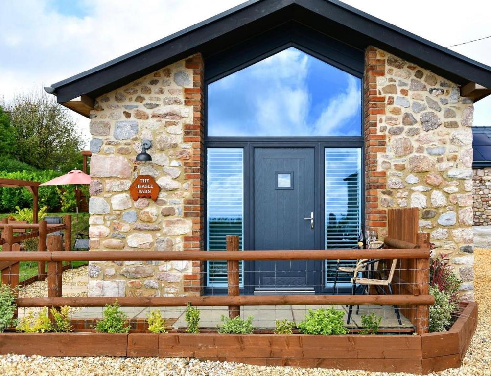 un chalet avec une porte noire et un balcon dans l'établissement 1 Bed in Rhossili oc-r33390, à Rhossili