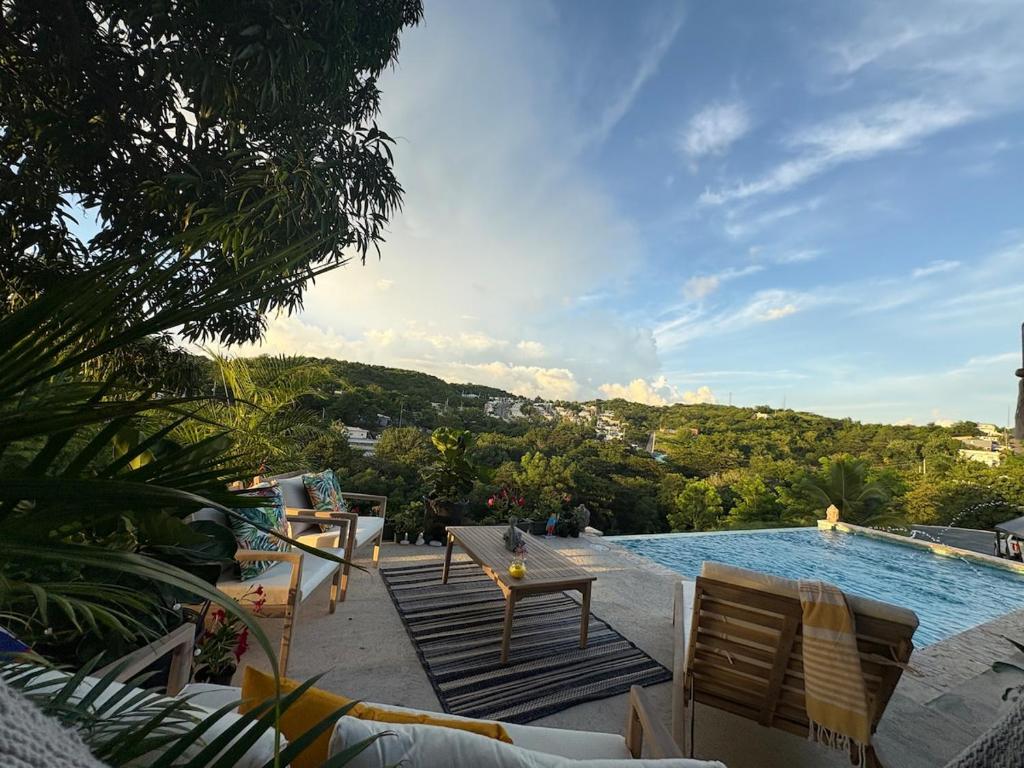a swimming pool with chairs and a table next to it at Lady Aura Casitas in Cabo Rojo, Puerto Rico in Cabo Rojo